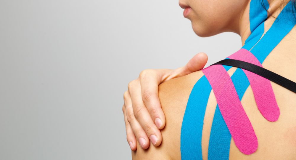 kinesiotaping-physiotherapie-leipzig-full Frau hat drei verschiedene Kinesiotapes am oberen Rücken